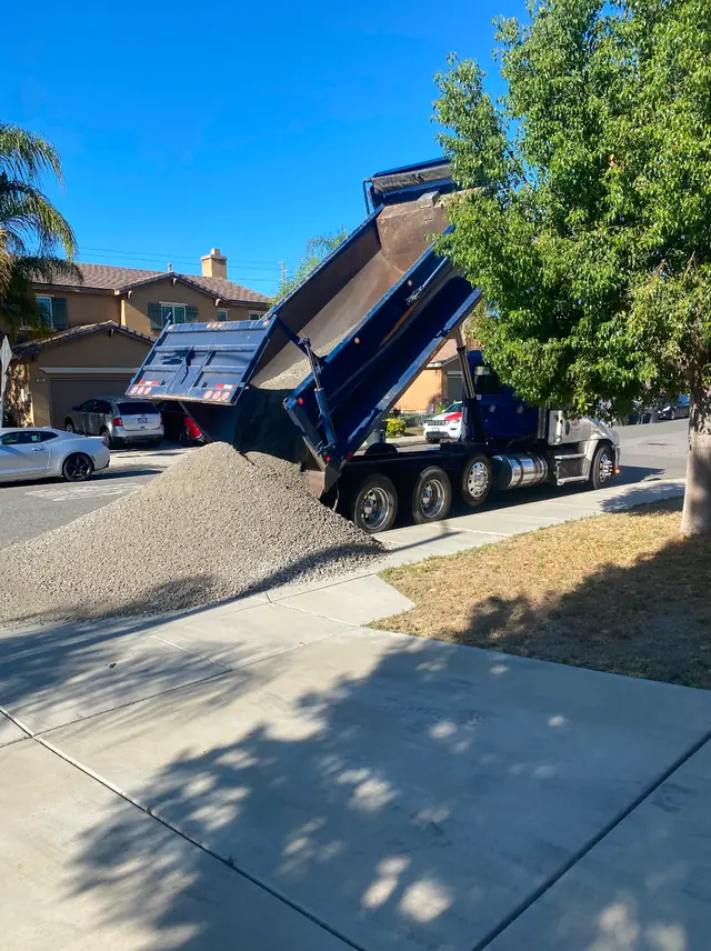 Dump truck delivering base material for a turf job in Perris, CA
