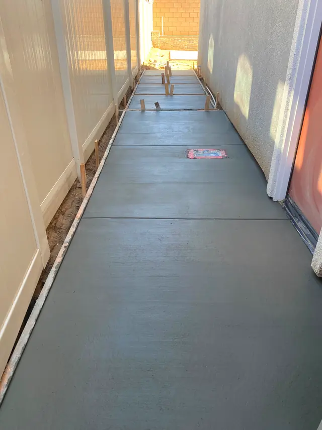 Poured concrete walkway in a narrow side yard in Perris, CA