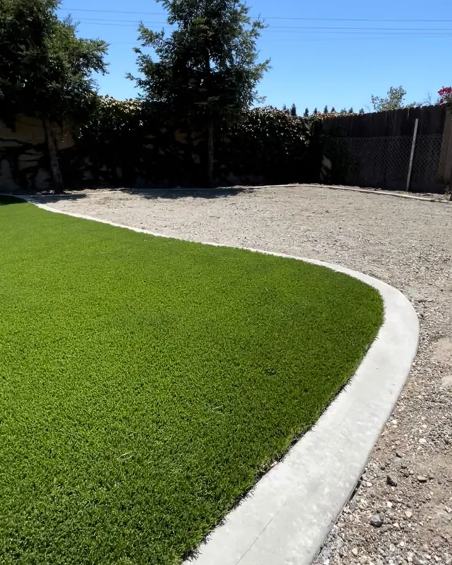 Artificial turf meeting a poured mow curb and gravel in Perris, CA